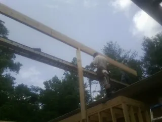Carpenter setting a ridge beam over a new addition frame — Ice Dam Removal by Roofing Brothers in Kiamesha Lake