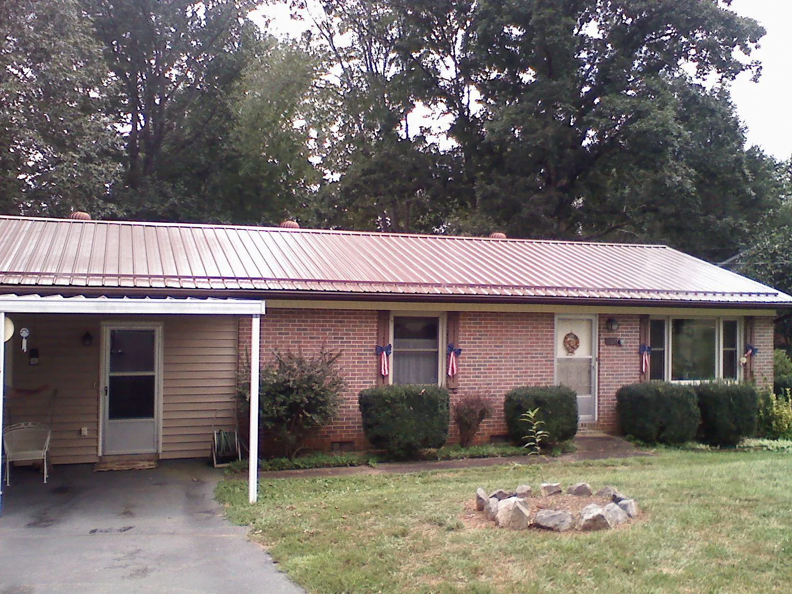Bronze metal roof and carport on a brick ranch home — Roof Repair work by our crew in Kiamesha Lake
